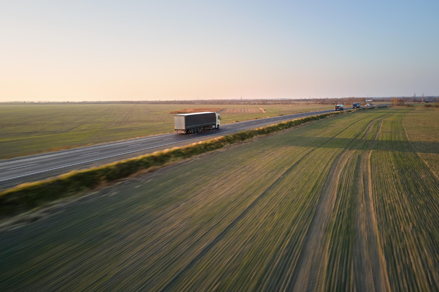 Camión atravesando una carretera rodeada de campos